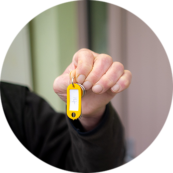 Man's hand holding up key.