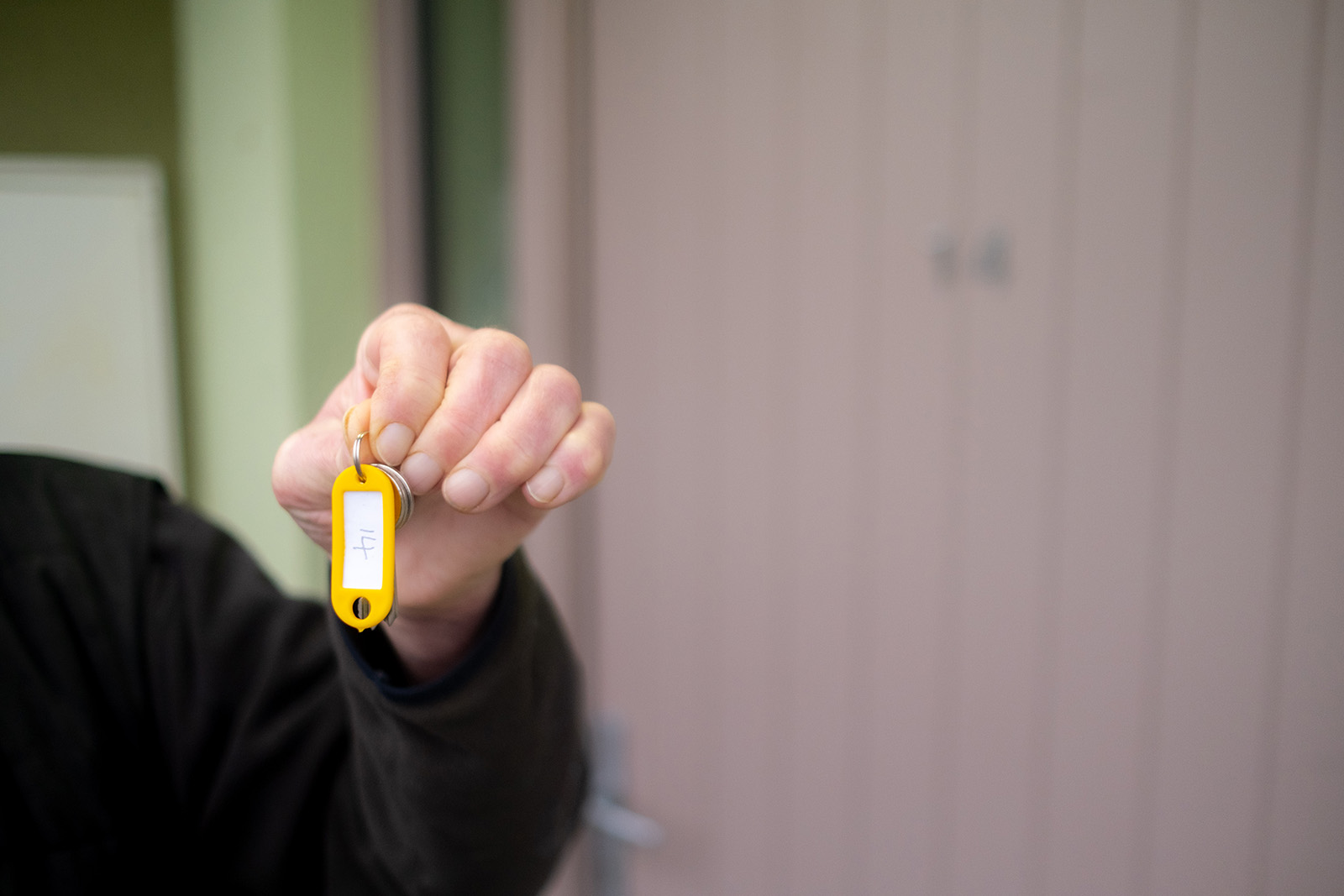 Close-up of man's hand holding up a key.